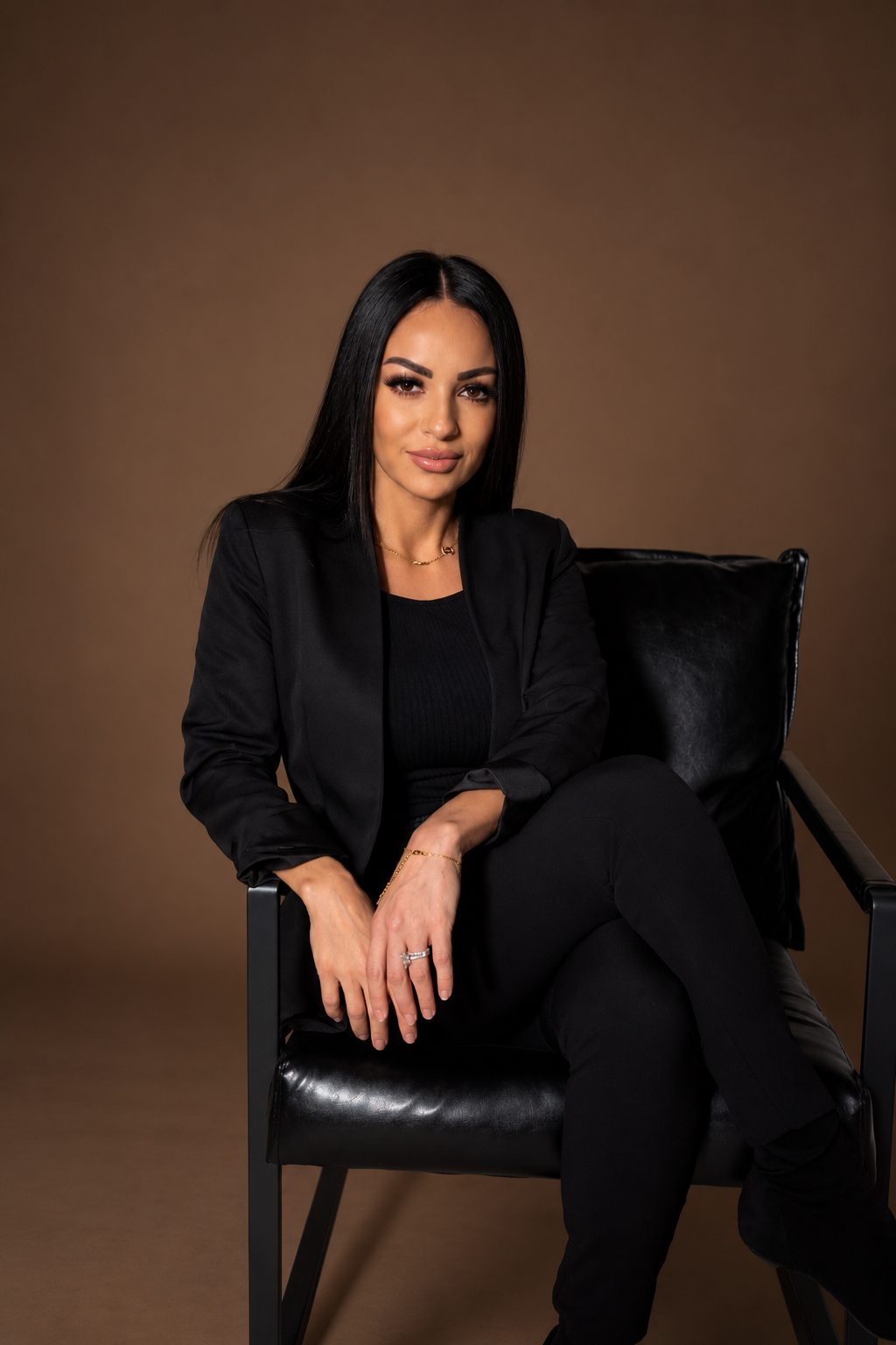 Coach Marcy seated in a black chair against a chocolate backdrop