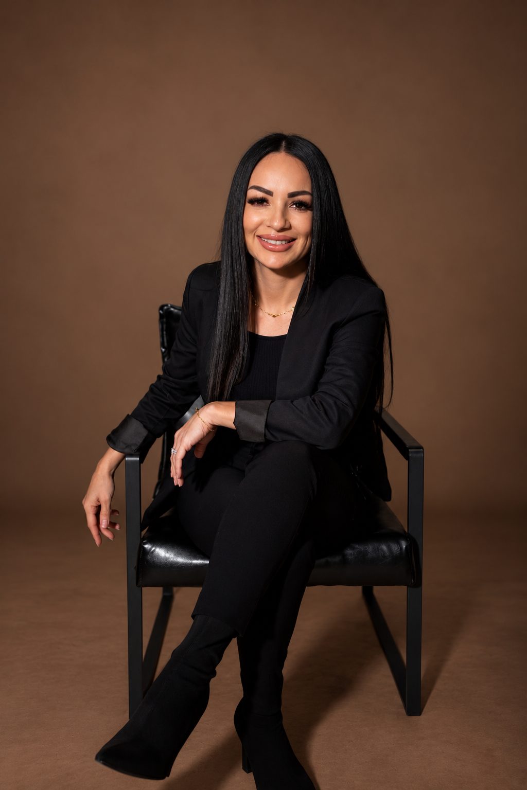 Coach Marcy smiling, seated in a black chair